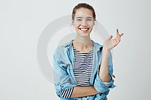 Laughter eases everyday problems. Charming woman in trendy outfit with bun hairstyle gesturing while talking to friend