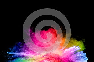 Launched colorful powder on black background.Color powder explosion.Colorful dust splashing photo