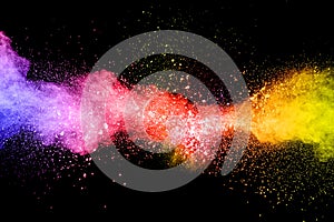 Launched colorful powder on black background.Color powder explosion.Colorful dust splashing photo