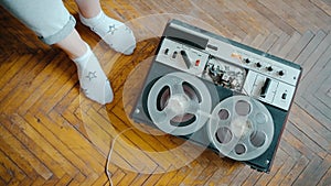 Launching an old reel-to-reel tape recorder close-up against the background.