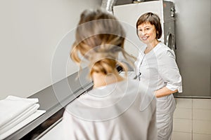 Laundress working with ironing machine