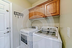 Laundry appliances inside small and functional utility room of residential home