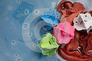 Laundry Balls, Multi-Colors In a bucket with ready-to-wash laundry, there is water and a small amount of detergent bubbles