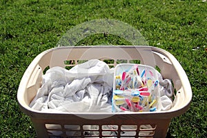 Laundry basket full of laundry ready to be hung out with colorful clothespins