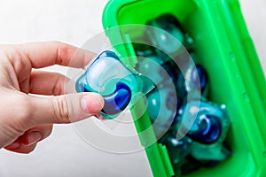 Laundry capsules on a white marble background. A package of washing powder for washing clothes in a washing machine.