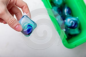 Laundry capsules on a white marble background. A package of washing powder for washing clothes in a washing machine.