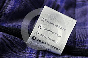 Laundry care label on scotch textile background