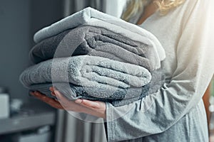 Laundry, cleaning and a woman with a pile of towels in her home for hygiene or a spring clean day. Hospitality, service