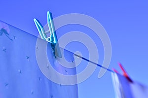 Laundry day clothes on clothesline colorful clothes pins against blue sky