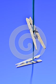 Laundry day clothes pins on clothesline against blue sky