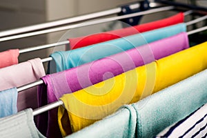 Laundry day Rainbow color clothes hanging on washing line to dry indoors home