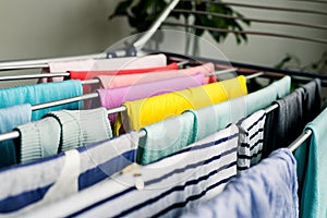 Laundry day Rainbow color clothes hanging on washing line to dry indoors home