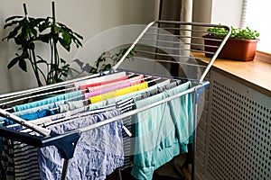 Laundry day Rainbow color clothes hanging on washing line to dry indoors home