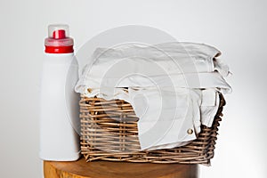 Laundry Detergent and Folded White Linen in a Basket
