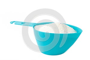 Laundry detergent powder for washing machine in plastic scoop isolated on white background