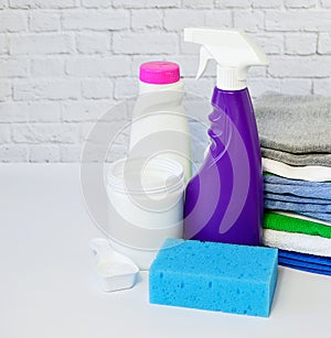 Laundry detergents: detergent, washing powder and a stack of clean clothes on on a white background. Copy space. The photo