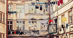 Laundry drying on a line with a tenement house in the background. Clothes hang on clothesline at house backyard. Laundry
