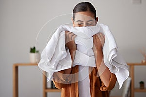 Laundry, fresh and woman smelling a towel after cleaning, housework and washing clothes in the morning. Chores