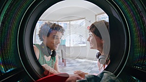 Laundry girl talking guy in self service closeup. Joyful teen couple enjoying