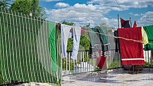 Laundry line with clothes on green tree background. Laundry drying on the roof