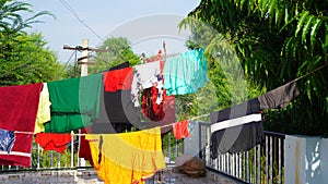 Laundry line with clothes on green tree background. Laundry drying on the roof