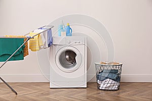 Laundry room interior with modern washing machine and drying rack