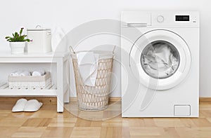 Laundry room interior with washing machine, basket and white shelves