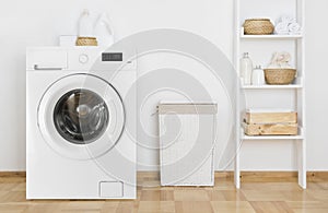 Laundry room interior with washing machine and shelf near wall