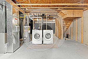 Laundry room with two white washers and dryers