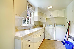 Laundry room with white old cabinets in large historical home.