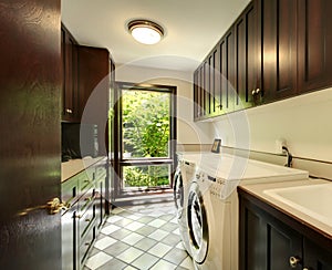 Laundry room with wood cabinets and white washer and dryer.