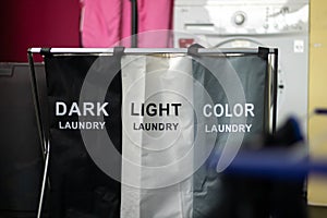 Laundry sorting basket with dark, light, and color laundry photo