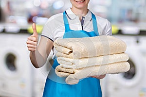 A laundry worker is holding clean towels