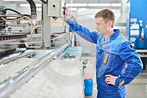 Laundry worker in the process of working on automatic machine for carpet washing