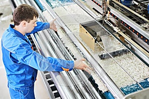 Laundry worker in the process of working on automatic machine for carpet washing