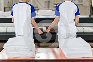 Laundry worker puts ironed textile