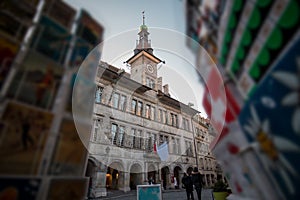 Lausanne City hall with clock tower in early afternoon, looking through the swiss vintage postcards in the foreground