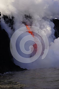 Lava flowing out of cliff suround with white cloud steam