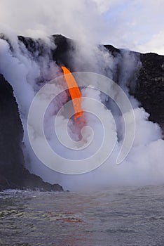 Lava flowing out of cliff suround with white cloud steam