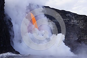 Lava flowing out of cliff suround with white cloud steam