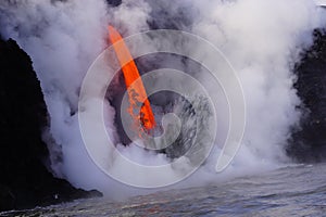 Lava flowing out of cliff suround with white cloud steam