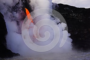 Lava flowing out of cliff suround with white cloud steam