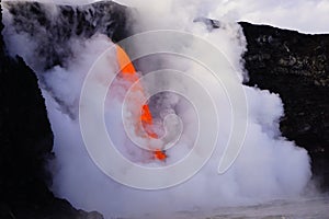 Lava flowing out of cliff suround with white cloud steam