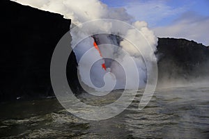 Lava flowing out of cliff suround with white cloud steam