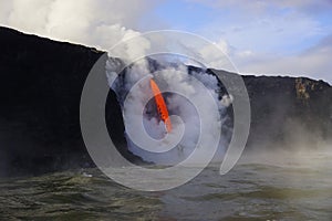 Lava flowing out of cliff suround with white cloud steam