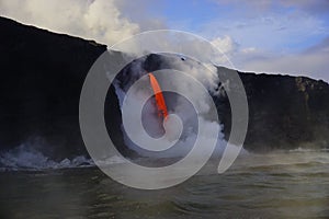 Lava flowing out of cliff suround with white cloud steam