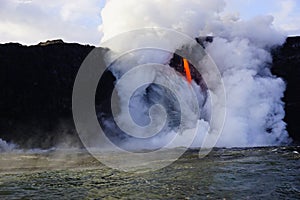 Lava flowing out of cliff suround with white cloud steam