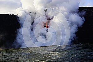 Lava flowing out of cliff suround with white cloud steam