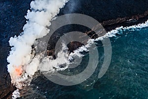 Lava flows into the cold water causing steam and gases to rise i