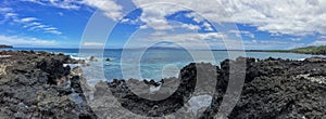 Lava Rock and Coral with Spray of crashing wave in tide pools at Maluaka Beach and Kihei Maui with sky and clouds